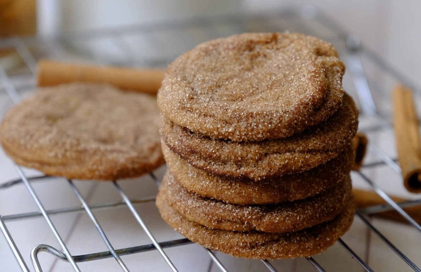 snickerdoodle cookies stacked on a metal grill.